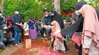 Aktris Oki Setiana Dewi bersama keluarga dan kerabat menaburkan bunga ke atas pusara almarhum ayahnya, Sulyanto di Pondok Pesantren Daarul Qur'an, Cipondoh, Tangerang, Banten, Jumat (4/6/2021). [Suara.com/Rena Pangesti]