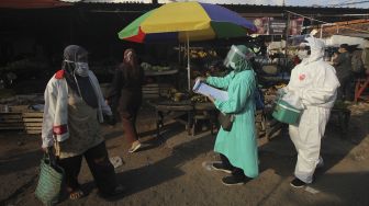 Petugas kesehatan mendatangi pedagang pasar untuk di tes usap PCR COVID-19 di Jalan Indrakila, Surabaya, Jawa Timur, Sabtu (5/6/2021). [ANTARA FOTO/Didik Suhartono]