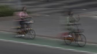 Pesepeda melintasi jalur khusus sepeda di Jalan Jenderal Sudirman, Jakarta, Sabtu (5/6/2021). [Suara.com/Angga Budhiyanto]