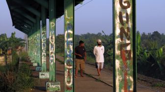 Warga berjalan di Stasiun Pondok Rajeg yang tidak aktif di Cibinong, Bogor, Jawa Barat, Senin (7/6/2021). ANTARA FOTO/Yulius Satria Wijaya
