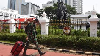 Prajurit TNI melintas di depan Patung Bung Karno di kompleks kantor Kementerian Pertahanan, Medan Merdeka Barat, Jakarta, Minggu (6/6/2021). ANTARA FOTO/Indrianto Eko Suwarso