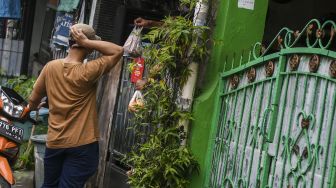 Kerabat memberikan paket bahan pangan ke warga yang menjalani isolasi mandiri di Jalan Intan Berduri, Kawasan Sumur Batu, Jakarta Pusat, Rabu (9/6/2021).  ANTARA FOTO/Galih Pradipta