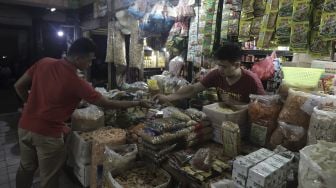 Pedagang melayani pembeli di Pasar Tebet Timur, Jakarta, Kamis (10/6/2021). [Suara.com/Angga Budhiyanto]