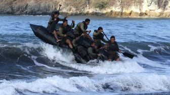 Prajurit Batalyon Intai Amfibi (Yontaifib) Korps Marinir TNI AL dan United States Marines Corps Reconnaissance Unit menerjang gelombang dalam Latihan Bersama Reconex 21-II di Pusat Latihan Pertempuran Marinir (Puslatpurmar) 7 Lampon, Banyuwangi, Jawa Timur, Jumat (11/6/2021). ANTARA FOTO/Budi Candra Setya
