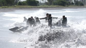 Prajurit Batalyon Intai Amfibi (Yontaifib) Korps Marinir TNI AL dan United States Marines Corps Reconnaissance Unit menerjang gelombang dalam Latihan Bersama Reconex 21-II di Pusat Latihan Pertempuran Marinir (Puslatpurmar) 7 Lampon, Banyuwangi, Jawa Timur, Jumat (11/6/2021). ANTARA FOTO/Budi Candra Setya
