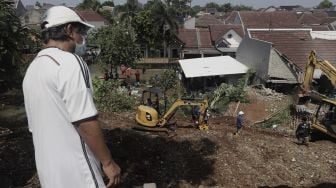 Warga melihat rumah yang hancur tertimpa tanah longsor di Perumahan Nerada Estate Ciputat, Tangerang Selatan, Banten, Sabtu (12/6/2021). [Suara.com/Angga Budhiyanto]