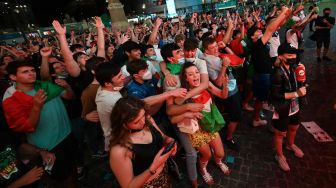 Warga dan para pendukung timnas Italia bergembira merayakan kemenangan tim mereka, seusai laga Turki vs Italia yang menjadi pembuka Euro 2020, di lokasi nonton bareng di Piazza del Popolo, Roma, Jumat (11/6/2021) malam atau Sabtu dini hari WIB. [ANDREAS SOLARO / AFP]