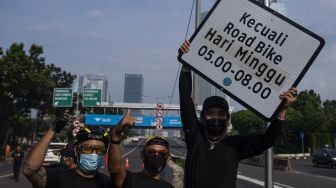 Sejumlah pesepeda dari Bike to Work Indonesia dan mitra koalisinya menunjukkan rambu bertuliskan �kecuali road bike� yang telah dicopot di sekitar Jalan Layang Non Tol (JLNT) Casablanca, Jakarta, Minggu (13/6/2021).  ANTARA FOTO/Sigid Kurniawan
