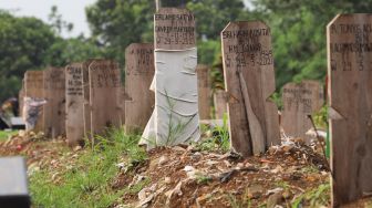 Makam - makam di area khusus Covid-19 yang diberi penanda kain di TPU Srengseng Sawah, Jakarta Sekatan, Minggu (13/6/2021). [Suara.com/Alfian Winanto]