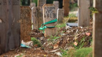 Makam - makam di area khusus Covid-19 yang diberi penanda kain di TPU Srengseng Sawah, Jakarta Sekatan, Minggu (13/6/2021). [Suara.com/Alfian Winanto]