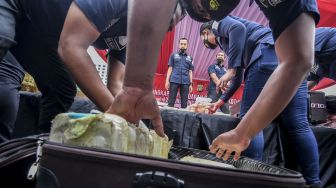 Petugas Kepolisian menata barang bukti berupa sabu saat pengungkapan kasus narkoba di Polda Metro Jaya, Jakarta, Senin (14/6/2021). ANTARA FOTO/Muhammad Adimaja