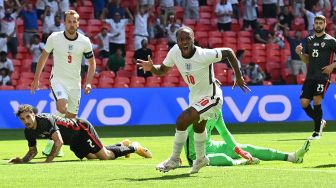 Pemain depan Inggris Raheem Sterling merayakan usai mencetak gol pertama timnya selama pertandingan sepak bola Grup D EURO 2020 antara Inggris melawan Kroasia di Wembley, London, Minggu (13/6/2021) malam WIB.
Glyn KIRK / POOL / AFP