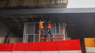 Sejumlah pekerja merampungkan pengerjaan proyek penataan kawasan Stasiun Tebet di Jakarta Selatan, Senin (14/6/2021). [Suara.com/Alfian Winanto]