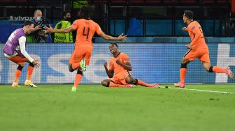 Bek Belanda Denzel Dumfries merayakan setelah mencetak gol ketiga selama pertandingan sepak bola Grup C EURO 2020 antara Belanda melawan Ukraina di Johan Cruyff Arena di Amsterdam, Belanda, Senin (14/6) dini hari WIB.  JOHN THYS / POOL / AFP