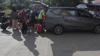 Pekerja Migran Indonesia (PMI) menaikkan barang bawaan ke dalam mobil usai menjalani isolasi di Rumah Sakit Darurat COVID-19 (RSDC) Wisma Atlet Pademangan, Jakarta, Selasa (15/6/2021). [Suara.com/Angga Budhiyanto]