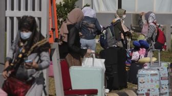 Sejumlah Pekerja Migran Indonesia (PMI) berjalan meninggalkan ruangan usai menjalani isolasi di Rumah Sakit Darurat COVID-19 (RSDC) Wisma Atlet Pademangan, Jakarta, Selasa (15/6/2021). [Suara.com/Angga Budhiyanto]