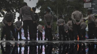 Refleksi personel kepolisian melakukan pengamanan saat massa mahasiswa melakukan aksi unjuk rasa di sekitar Gedung Komisi Pemberantasan Korupsi (KPK), Jakarta, Rabu (16/6/2021). [Suara.com/Angga Budhiyanto] 