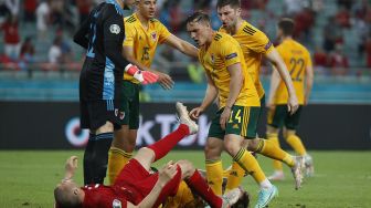 Connor Roberts dari Wales bentrok dengan Burak Yilmaz dari Turki pada pertandingan Euro 2020, di Stadion Olimpiade Baku, Baku, Azerbaijan, Kamis (17/6/2021) dini hari WIB.  TOLGA BOZOGLU / KOLAM RENANG / AFP
