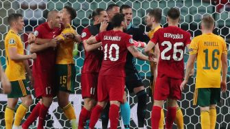 Connor Roberts dari Wales bentrok dengan Burak Yilmaz dari Turki pada pertandingan Euro 2020, di Stadion Olimpiade Baku, Baku, Azerbaijan, Kamis (17/6/2021) dini hari WIB.  TOLGA BOZOGLU / KOLAM RENANG / AFP
