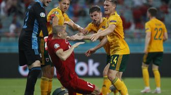 Connor Roberts dari Wales bentrok dengan Burak Yilmaz dari Turki pada pertandingan Euro 2020, di Stadion Olimpiade Baku, Baku, Azerbaijan, Kamis (17/6/2021) dini hari WIB.  TOLGA BOZOGLU / KOLAM RENANG / AFP
