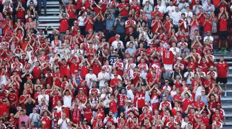 Suporter Denmark membentangkan spanduk dukungan untuk Christian Eriksen saat laga Piala Eropa 2020 Grup B antara Denmark melawan Belgia di Parken Stadium, Copenhagen, Kamis (17/6/2021).  [AFP/Photo]