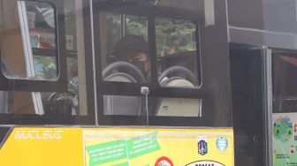 Para pasien Covid-19 menunggu didalam bus jemputan untuk dievakuasi ke RSDC Wisma Atlet di Puskesmas Lubang Buaya, Jakarta Timur, Jumat (18/6/2021). [Suara.com/Alfian Winanto]