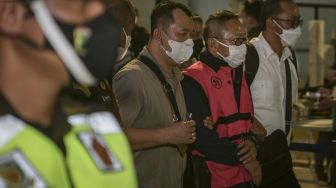 Terpidana kasus pembalakan liar Adelin Lis (kedua kanan) dibawa oleh petugas setibanya di Bandara Soekarno Hatta, Tangerang, Banten, Sabtu (19/6/2021). [ANTARA FOTO/Fauzan]