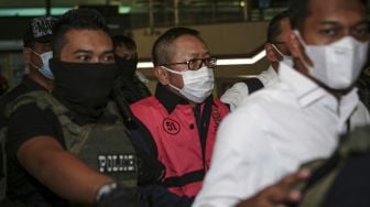 Terpidana kasus pembalakan liar Adelin Lis (tengah) dibawa oleh petugas setibanya di Bandara Soekarno Hatta, Tangerang, Banten, Sabtu (19/6/2021). [ANTARA FOTO/Fauzan]
