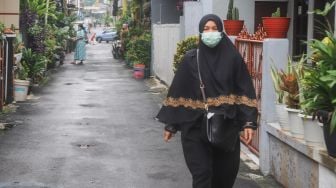 Warga beraktivitas dengan menggunakan masker di Kampung Tangguh Jaya RW 13 Bidara Cina, Jakarta Timur, Sabtu (19/6/2021). [Suara.com/Alfian Winanto]