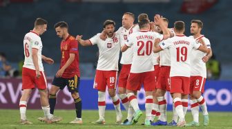 Para pemain Polandia merayakan hasil imbang mereka selama pertandingan sepak bola Grup E UEFA EURO 2020 antara Spanyol dan Polandia di Stadion La Cartuja, Seville, Spanyol, pada (19/6/2021). [David Ramos / POOL / AFP]