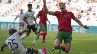 Bek Portugal Ruben Dias (kanan) berbenturan dengan pemain depan Jerman Thomas Mueller (kiri) selama pertandingan sepak bola Grup F UEFA EURO 2020 antara Portugal dan Jerman di Allianz Arena, Munich pada (19/6/2021). [Matthias Schrader / POOL / AFP]