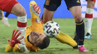 Penjaga gawang Polandia Wojciech Szczesny mencoba merebut bola selama pertandingan sepak bola Grup E UEFA EURO 2020 antara Spanyol dan Polandia di Stadion La Cartuja, Seville, Spanyol, pada (19/6/2021). [LLUIS GENE / POOL / AFP]