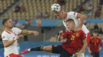 Bek Polandia Kamil Glik (kanan) berebut bola dengan gelandang Spanyol Daniel Olmo (tengah) selama pertandingan sepak bola Grup E UEFA EURO 2020 antara Spanyol dan Polandia di Stadion La Cartuja, Seville, Spanyol, pada (19/6/2021). [David Ramos / POOL / AFP]