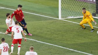 Pemain Spanyol Alvaro Morata (tengah) melakukan tendangan untuk mencetak gol pembuka pada pertandingan sepak bola Grup E UEFA EURO 2020 antara Spanyol dan Polandia di Stadion La Cartuja, Seville, Spanyol, pada (19/6/2021). [Jose Manuel Vidal / POOL / AFP]