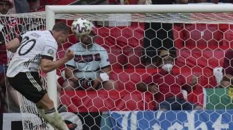 Bek Jerman Robin Gosens (kiri) mencetak gol keempat mereka selama pertandingan sepak bola Grup F UEFA EURO 2020 antara Portugal dan Jerman di Allianz Arena, Munich pada (19/6/2021). [Matthias Schrader / POOL / AFP]