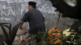 Seniman menyelesaikan pembuatan ondel-ondel Betawi ukuran besar di kawasan Jagakarsa, Jakarta Selatan, Senin (21/6/2021). [Suara.com/Angga Budhiyanto]