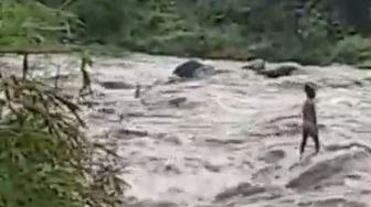 Mendebarkan! Bocah Terjebak Banjir Bah saat Asyik Menjala Ikan di Sungai