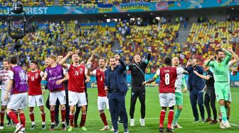 Para pemain Austria bersama para staf merayakan kepastian timnya lolos 16 besar Euro 2020 di National Arena, Senin (21/6/2021).  [Foto/AFP]