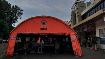 Suasana halaman parkiran yang di dirikan tenda BNPB di RSUD dr.Chasbullah Abdulmadjid, Bekasi, Rabu (23/6/2021).  [Suara.com/Dian Latifah]
