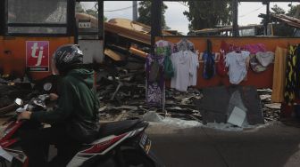 Pengendara sepeda motor melintas di depan tempat pemotongan bus Transjakarta di Terminal Pulogadung, Jakarta, Kamis (24/6/2021). [Suara.com/Angga Budhiyanto]