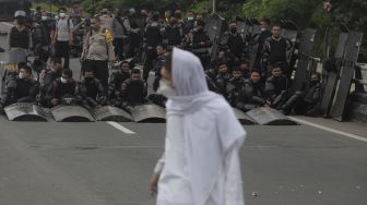 Polisi memblokade massa pendukung Rizieq Shihab di kawasan I Gusti Ngurah Rai saat akan menuju Pengadilan Negeri (PN) Jakarta Timur, Kamis (24/6/2021). [Suara.com/Angga Budhiyanto]