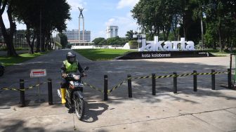 Petugas berkendara keluar dari Taman Lapangan Banteng yang ditutup untuk sementara waktu di Jakarta, Jumat (25/6/2021). ANTARA FOTO/Akbar Nugroho Gumay