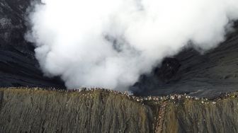 Foto udara warga berada di bibir kawah Gunung Bromo melaksanakan upacara ritual Yadnya Kasada di Tengger, Probolinggo, Jawa Timur, Sabtu (26/6/2021). [ANTARA FOTO/Budi Candra Setya]