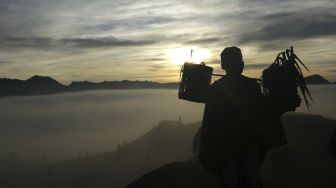 Warga berjalan menuju bibir kawah Gunung Bromo membawa sesaji hasil bumi saat ritual Yadnya Kasada di Tengger, Probolinggo, Jawa Timur, Sabtu (26/6/2021). [ANTARA FOTO/Budi Candra Setya]