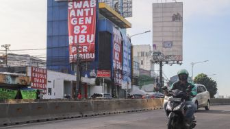 Spanduk besar mempromosikan harga tes swab antigen dan PCR ramai terpampang di kawasan Warung Buncit, Jakarta Selatan, Sabtu (26/6/2021). [Suara.com/Alfian Winanto]