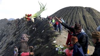 Warga melempar sesaji berupa hasil bumi ke kawah Gunung Bromo saat ritual Yadnya Kasada di Tengger, Probolinggo, Jawa Timur, Sabtu (26/6/2021). [ANTARA FOTO/Budi Candra Setya]
