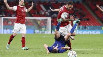 Pemain depan Austria Marko Arnautovic (atas) melakukan pelanggaran terhadap gelandang Italia Jorginho (bawah) selama pertandingan sepak bola babak 16 besar UEFA EURO 2020 antara Italia dan Austria di Stadion Wembley, London, pada (26/6/2021). [Catherine Ivill / POOL / AFP]