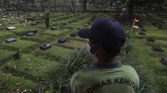 Petugas berada di Tempat Pemakaman Umum (TPU) Karet Bivak, Jakarta, Minggu (27/6/2021). [Suara.com/Angga Budhiyanto]