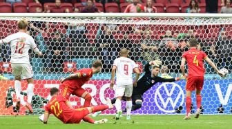 Pemain depan Denmark Kasper Dolberg (kiri) mencetak gol pertama mereka selama pertandingan sepak bola babak 16 besar UEFA EURO 2020 antara Wales dan Denmark di Johan Cruyff Arena, Amsterdam, pada (26/6/2021). [Olaf Kraak / POOL / AFP]