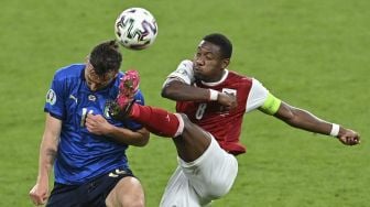 Gelandang Italia Bryan Cristante (kiri) dan bek Austria David Alaba berebut bola selama perpanjangan waktu dalam pertandingan sepak bola babak 16 besar UEFA EURO 2020 antara Italia dan Austria di Stadion Wembley, London, pada (26/6/2021). [JUSTIN TALLIS / POOL / AFP]